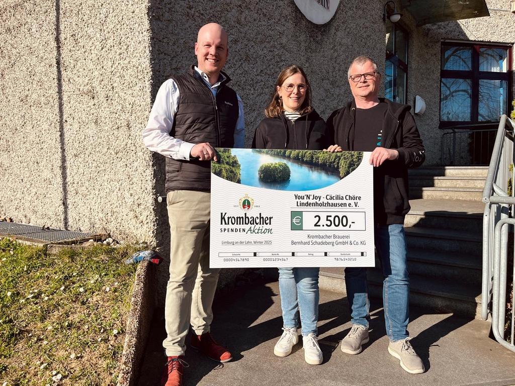  Der Krombacher Gebietsverkaufsleiter Stefan Metzler übergibt den Spendenscheck an Julia Bergmann und Klaus Thein von You'N'joy. 