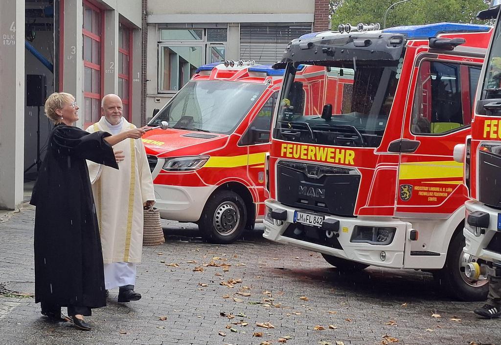Pfarrerin Susanne Stock und Diakon Wolfgang Zernig segnen die neuen Fahrzeuge der Limburger Feuerwehr.